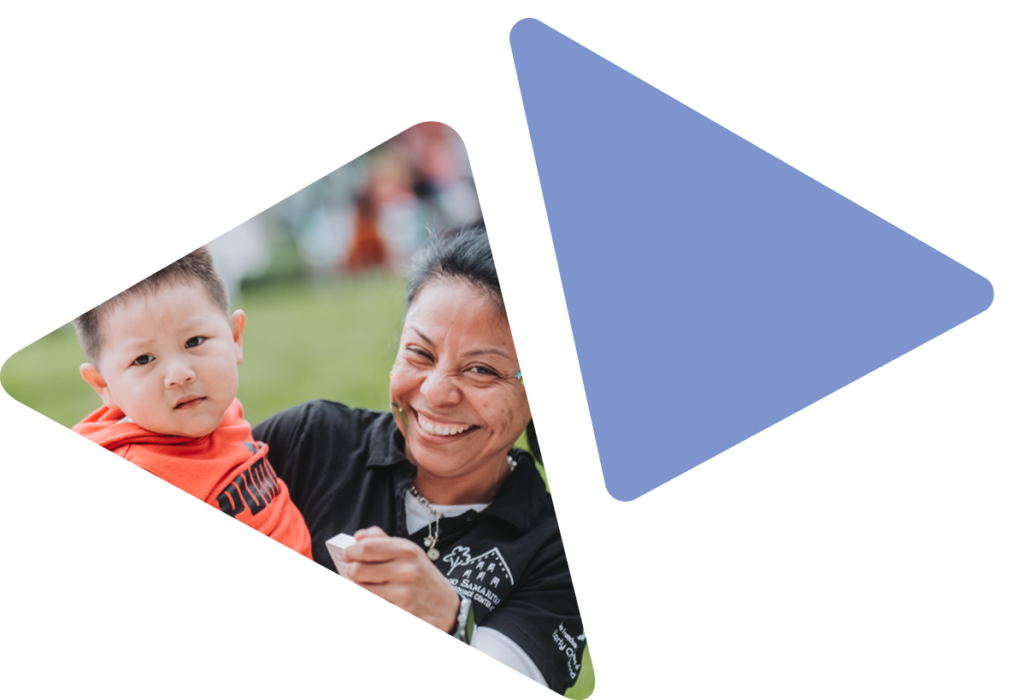woman holding toddler and smiling at camera