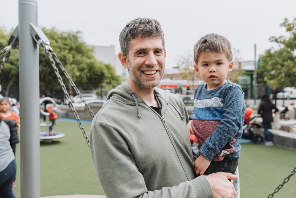 father holding toddler child outside
