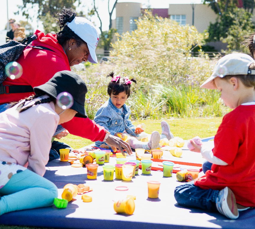 Young children playing outside on picnic blanket