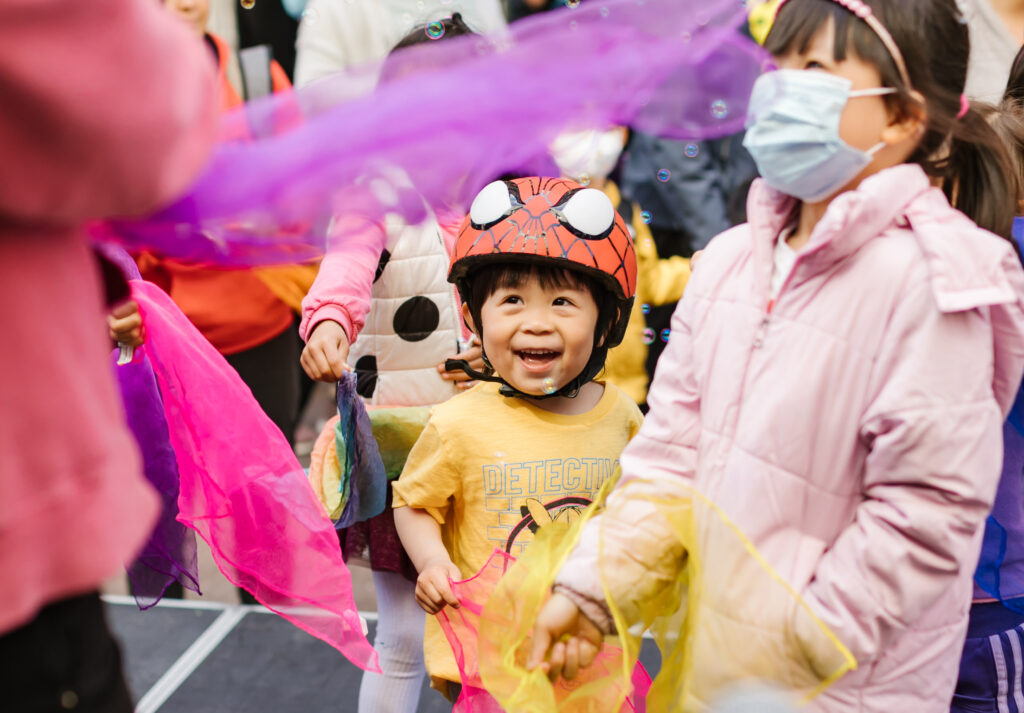 close up on happy toddler and children outside at street festival